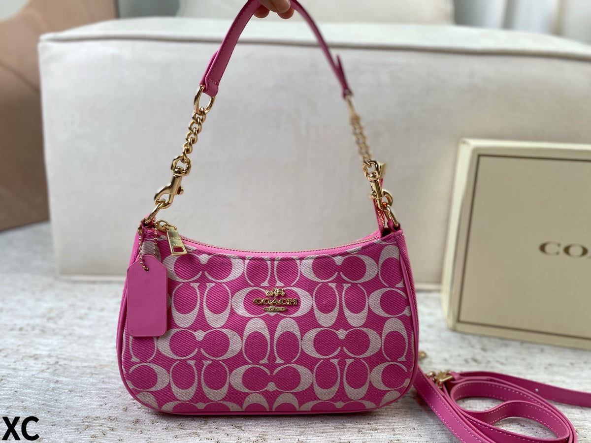 A pink and white Coach signature pattern shoulder bag with gold hardware, shown with its matching pink leather strap and a Coach box in the background.