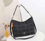 Black patterned handbag with Coach logo on a white surface