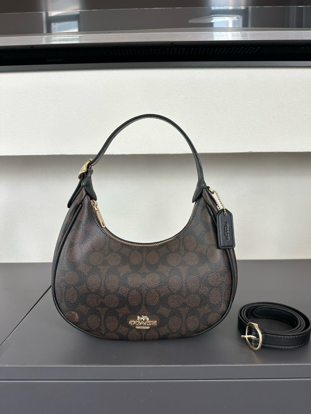 Coach handbag with a patterned design on a reflective surface