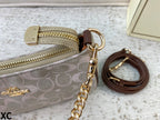 A close-up of a Coach zip pouch in the signature monogram canvas, featuring gold-tone hardware, a brown leather wristlet strap, and a gold logo on a textured light background.