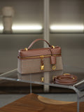 A structured handbag with a brown leather top handle and trim, combined with a beige and brown houndstooth patterned body, displayed on a glass table with its matching brown strap nearby.