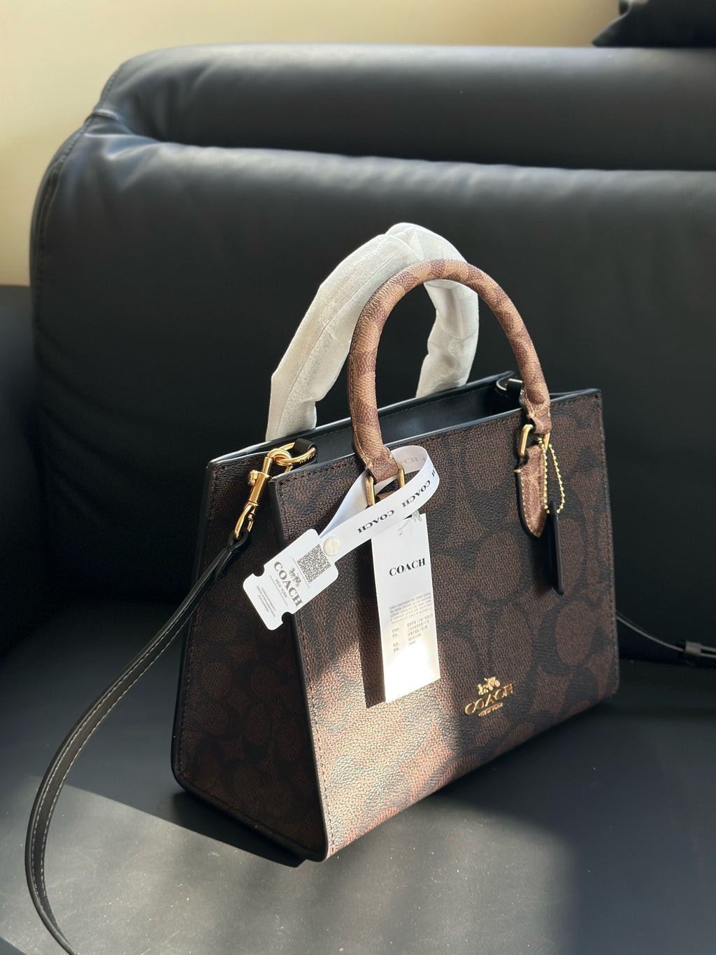 Brown handbag with a visible brand tag on a dark surface