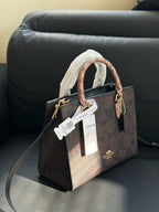 Brown handbag with a visible brand tag on a dark surface