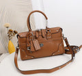 A brown leather handbag with a top handle, front flap pockets, silver-tone studs and hardware, and a detachable shoulder strap, displayed on a white surface with a decorative vase in the background.