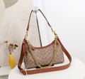 A Coach hobo shoulder bag in signature monogram canvas with brown leather trim and gold-tone chain and strap hardware, displayed on a white pedestal in a styled interior setting.